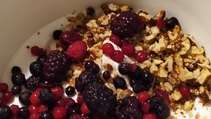 Διπλώνοντας φρούτα του δάσους και καραμελωμένους ξηρούς καρπούς στη μαρέγκα