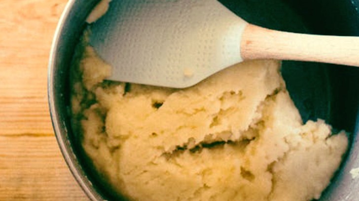 The tart dough in a bowl with a spatula