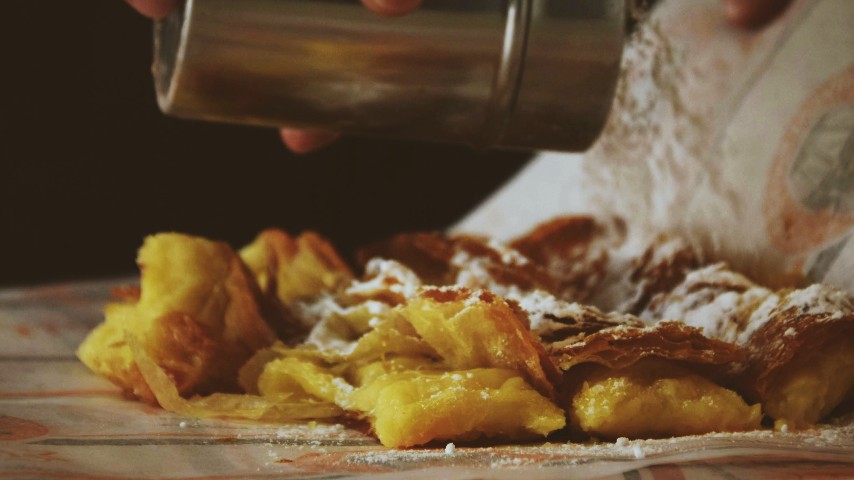 Greek bougatsa sprinkled with powdered sugar and cinnamon, cut in pieces
