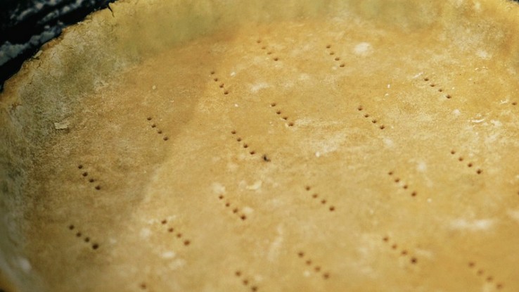 The pre-baked tart with fork holes on the bottom