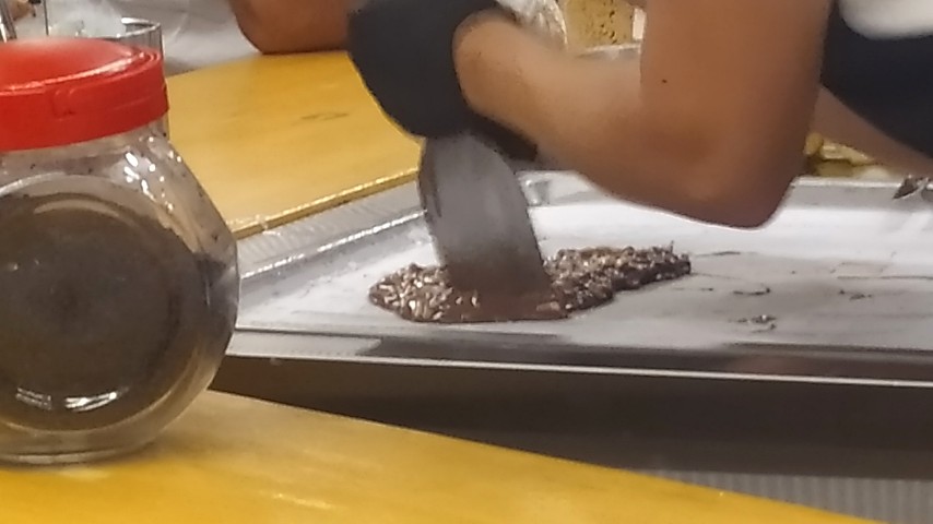 Η υπάλληλος κόβει το μίγμα με τις σπάτουλες