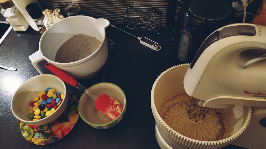 Bowls containing the ingredients for the cookies, a mixer and cooking tools