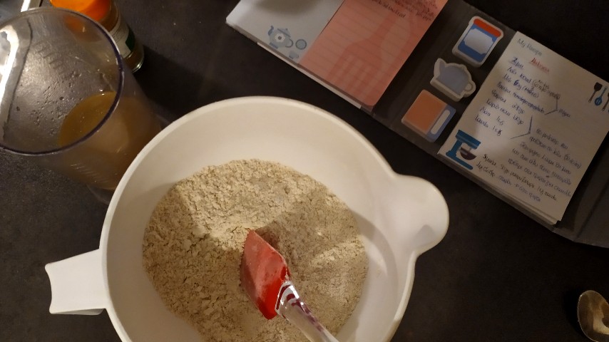 Μπολ με τα στερεά υλικά, δοχείο με τα υγρά και σημειωματάριο, σε πάγκο κουζίνας