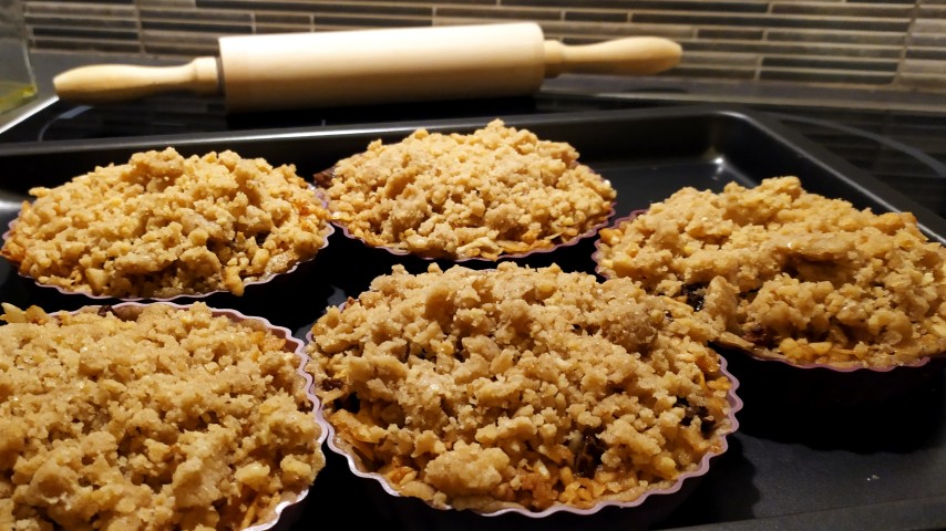 Πέντε ατομικές μηλόπιτες σε φόρμες σιλικόνης και ένας πλάστης στο βάθος