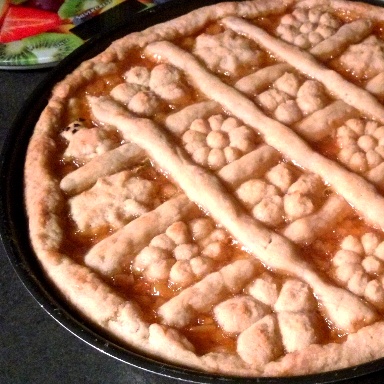 Ένα ταψί με πάστα φλώρα, με διακόσμηση ζύμης σε σχήματα λουλουδιών