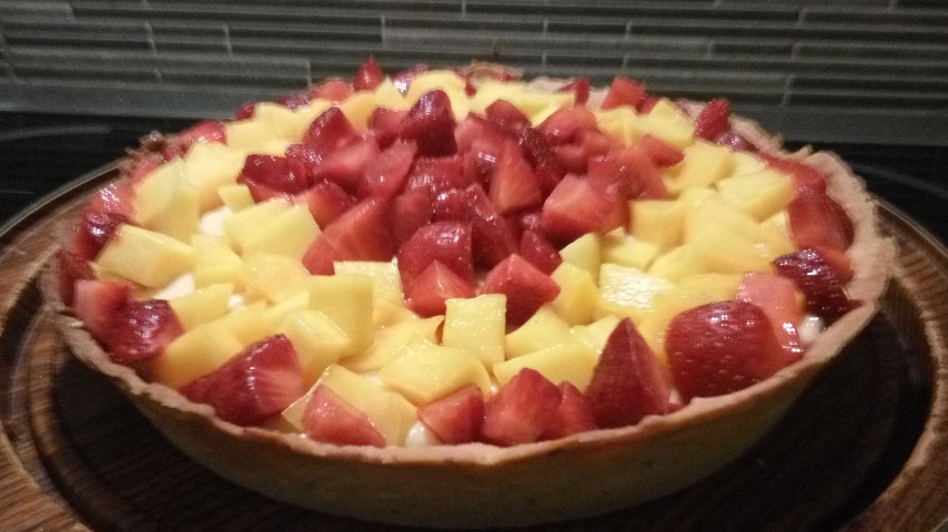 Τάρτα με μάνγκο και φράουλες σε ξύλινο δίσκο